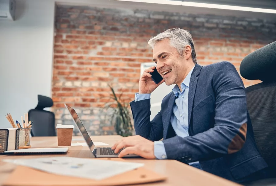 A busy-well dressed man on the phone in his office, to represent Wise &Partners' experience serving core millionaires and accomplished professionals